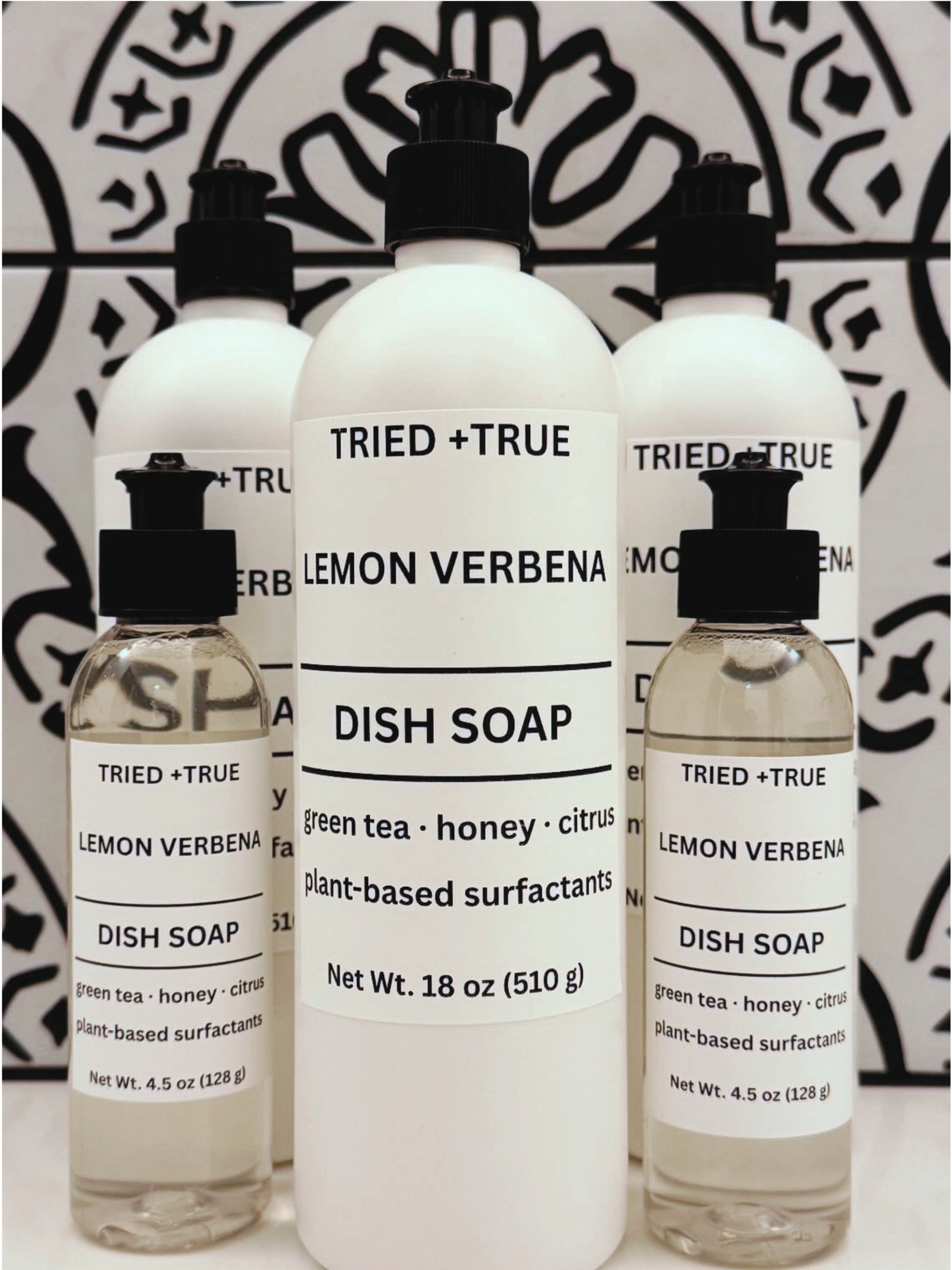 Tried + True Dish Soap on a white surface with a black and white patterned background.